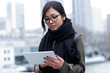 © nenetus - Beautiful asian young woman using her digital tablet in front of Seine river in Paris.