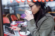 © nenetus - Beautiful young asian woman using her digital tablet while drinking coffee in coffee shop.