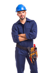 Wall Mural - Portrait of a serious young worker standing with arms crossed on white background