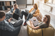 © Yakobchuk Olena - Tranquil men and women sitting with comfort in their modern office. Girl with project documentation in hand looking at camera while her partners using gadgets
