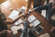 © Yakobchuk Olena - Top view of male and female people holding hands in conjunction above working table