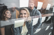 © Yakobchuk Olena - Four young people looking at paper notes glued on window glass. They have concentrated expressions