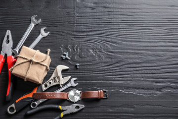 Flat lay composition with gift box, watch and instruments on wooden background. Father's day celebration