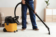 © New Africa - Male worker cleaning carpet with vacuum in living room