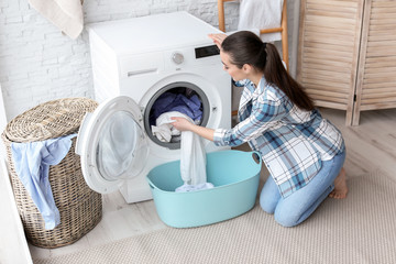 Wall Mural - young woman doing laundry at home