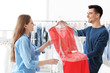 © New Africa - Young woman receiving her dress at dry-cleaner's