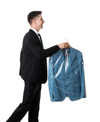 Canvas Print - Young businessman holding hanger with jacket in plastic bag on white background. Dry-cleaning service