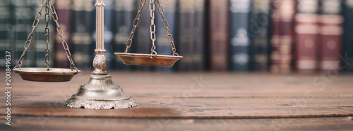 Cuadros en Lienzo Scales of Justice and Law books on a wooden background.