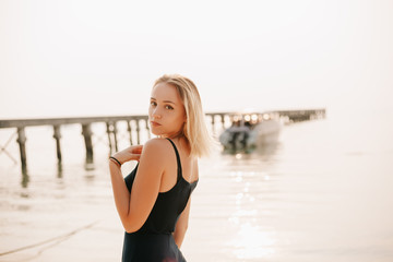 portrait of attractive girl in dress looking at camera on beach