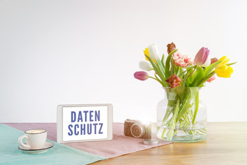 Wall Mural - Tablet with Datenschutz writing in german meaning data privacy in english on wooden desk with white background