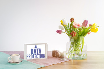 Wall Mural - Tablet with data protection writing on wooden desk with white background