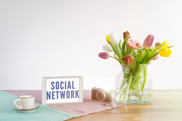 Wall Mural - Tablet with social network writing on wooden desk with white background