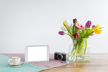 Wall Mural - Tablet screen with copy space and flowers on wooden desk with white background
