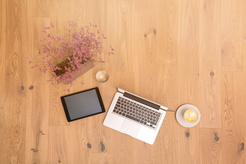Wall Mural - Laptop and tablet with copy space on wooden floor as flat lay
