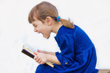 The child is reading a book. Selective focus.  