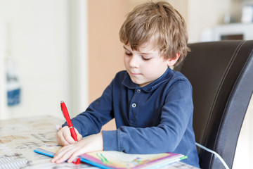 Wall Mural - preschool kid boy at home making homework writing letters with colorful pens