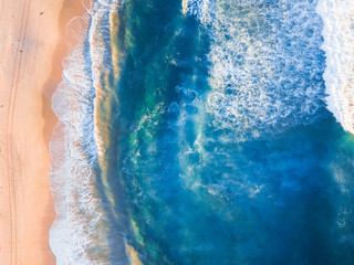 aerial view of clean coastline under morning golden light.