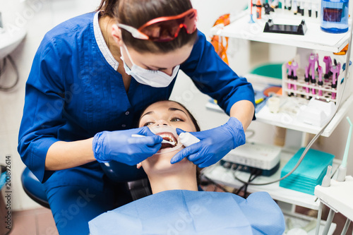 Fotografia Dentist holding tooth whitening procedure