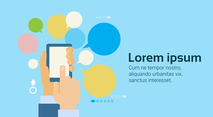 Wall Mural - hand holding smart phone or digital tablet computer over chat bubbles background flat vector illustr