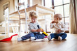 © Halfpoint - Two toddlers with brush and dustpan at home.