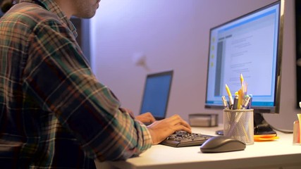 deadline, technology and people concept - programmer with computer working together late at night office