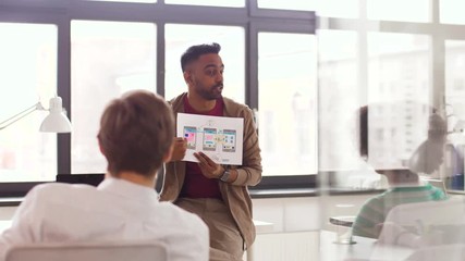 business, technology and software development concept - man showing user interface mockup to creative team at office