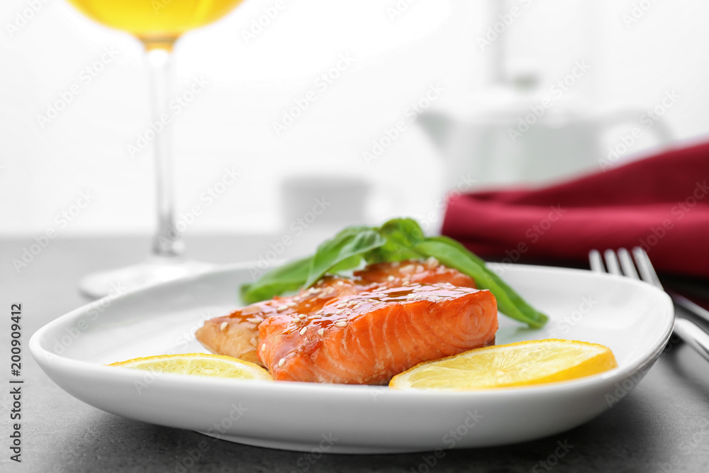 Fish fillet served with lemon slices and fresh basil leaves on kitchen table