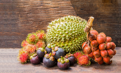 Summer fruits, rambutan, mangosteen, durian taking place on a wooden table