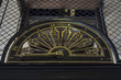 turn of the century elevator . close up on elevator's floor indicator. The elevator itself is iron painted black, the numbers and indicator are bronze