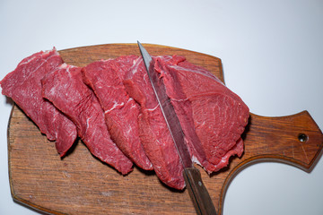 Meat beef fresh, on a board and knife on a white background