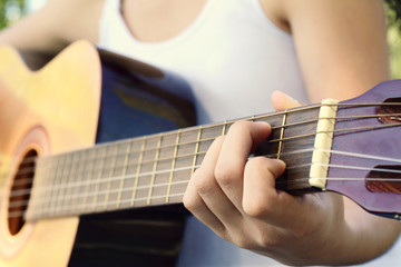 Wall Mural - Woman playing guitar at the park.