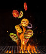 Flying pieces of vegetable from grill grid, isolated on black background