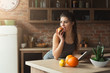 © Prostock-studio - Happy young woman eating fruits in kitchen