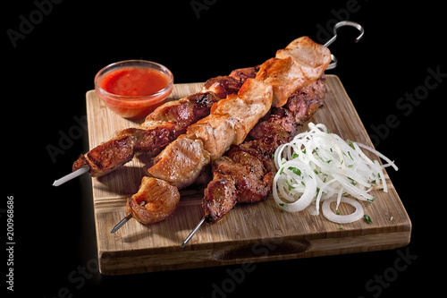 Fotomural Traditional Russian shashlik on a barbecue skewer on black background