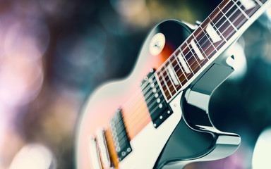 Close up shot of a guitar, over blured lights background