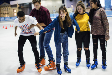 Group of teenage friends ice skating on an ice rink