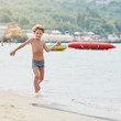 © Denys Kurbatov - Smiling boy enjoying summer vacation and playing on the beach, image with square aspect ratio