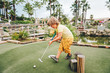 © annanahabed - Funny kid boy playing mini golf, child enjoying summer vacation