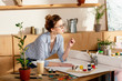 © LIGHTFIELD STUDIOS - young female artist in eyeglasses standing at table with empty canvas and painting supplies