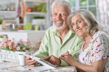 portrait of happy beautiful senior couple using tablet  