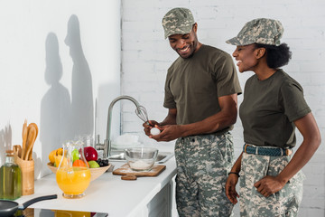 Wall Mural - Couple of soldiers cooking together at home kitchen