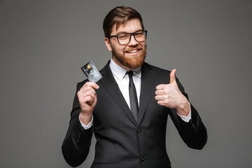 Poster - Portrait of a happy young businessman holding credit card