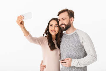 Wall Mural - Happy young loving couple make selfie using mobile phone.