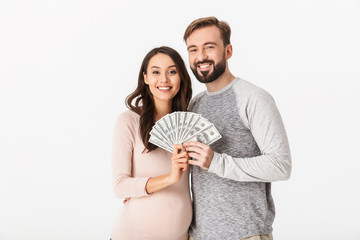 Wall Mural - Happy young loving couple holding money looking camera.