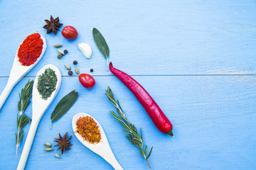 Set of spices and herbs on blue wooden background