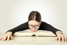 Studio Portrait Of Young Woman In Front Of Big Book On The Table, Don't Feel Like Studying Concept