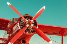 Red Biplane On Sky Background. Close-up With Engine And Propeller