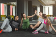 © Prostock-studio - Group of sporty people sitting on floor at gym