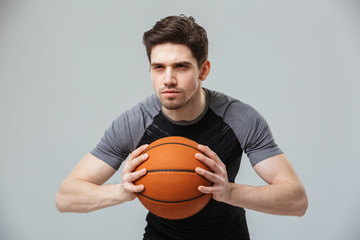 Wall Mural - Portrait of a focused young sportsman playing basketball