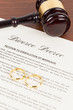 © wirojsid - Wooden judge gavel, golden rings, and divorce decree; document is mock-up